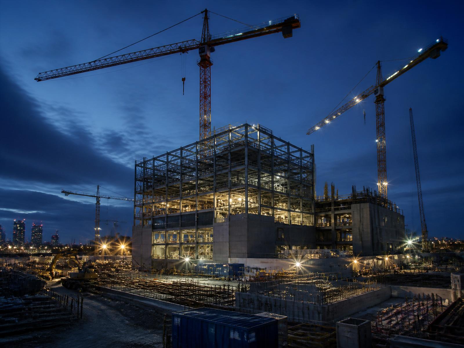 Structural steel frame under construction with tower cranes